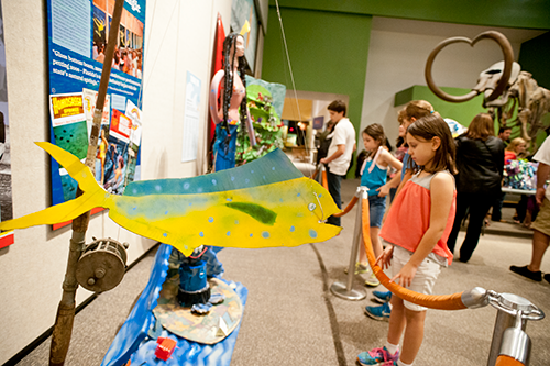 Visitors explore art created for the Trashformations competition at the Florida Museum. Students in middle school, high school and college are encouraged to participate. ©Florida Museum photo by Kristen Grace Visitors look at Trashformations entries.