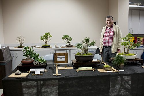 Jay Beckenbach stands with his bonsai collection. 