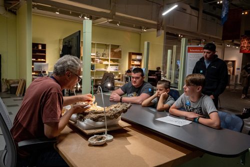 volunteer talking to guests in Science Up Close exhibit