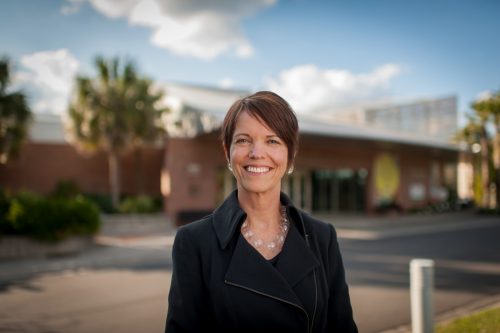 woman smiling in front of building