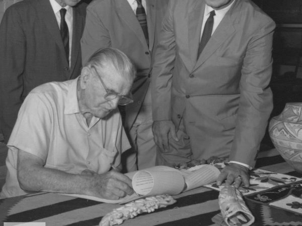 four men signing document