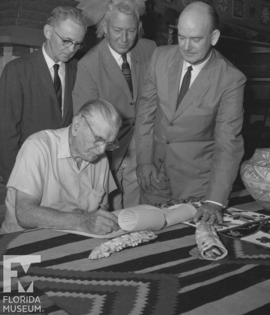 four men signing document