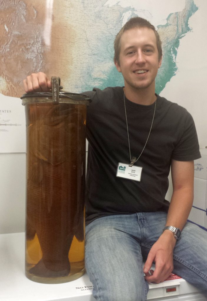 David sitting next to the large specimen jar