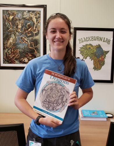 student holding the book she illustrated