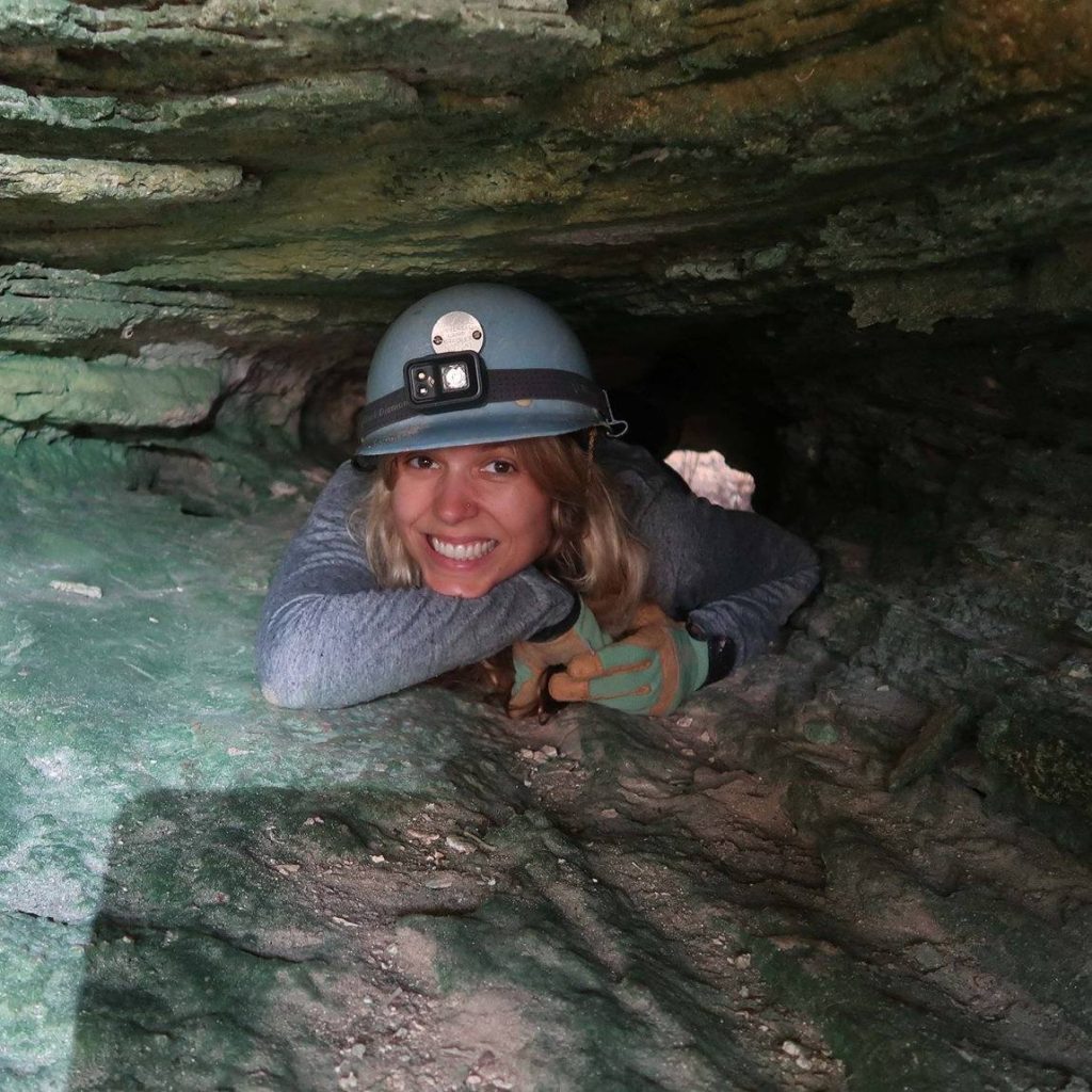researcher wearing a hard hat in a cave