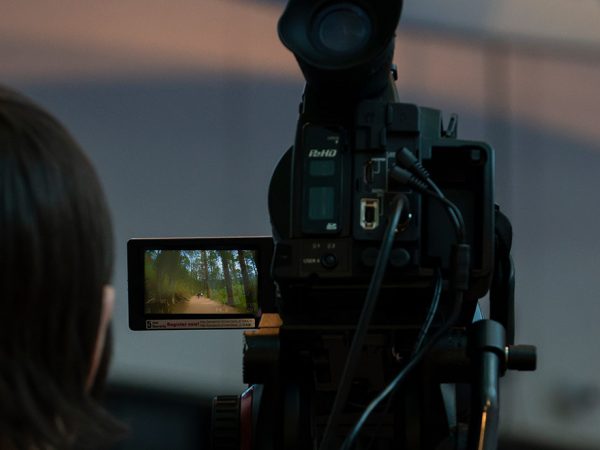 shadowed man with video recording equipment