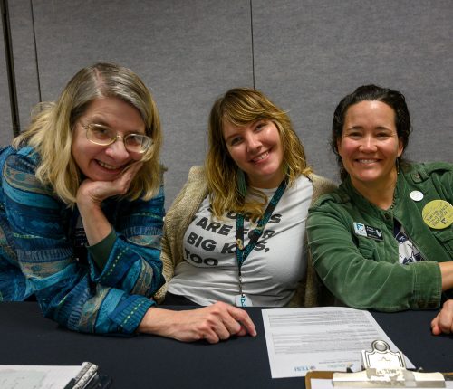 three museum staff smiling at the camera