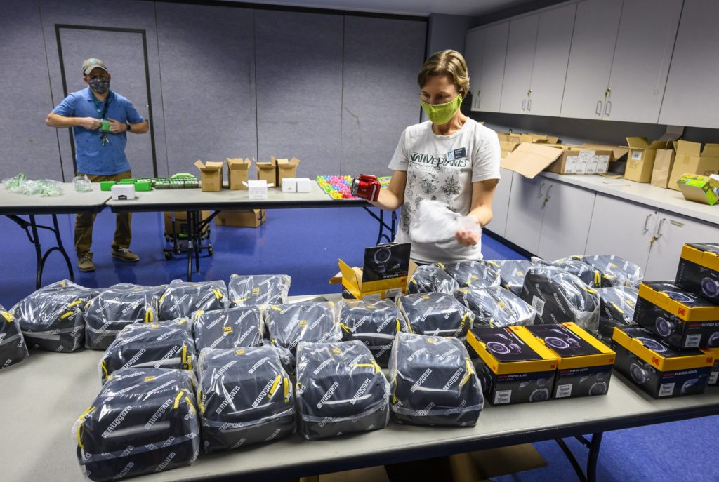 This image shows two people unwrapping cameras in a classroom at the Florida Museum.