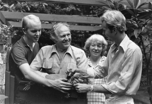 vintage black and white photo of a family holding a large lizard-like animal