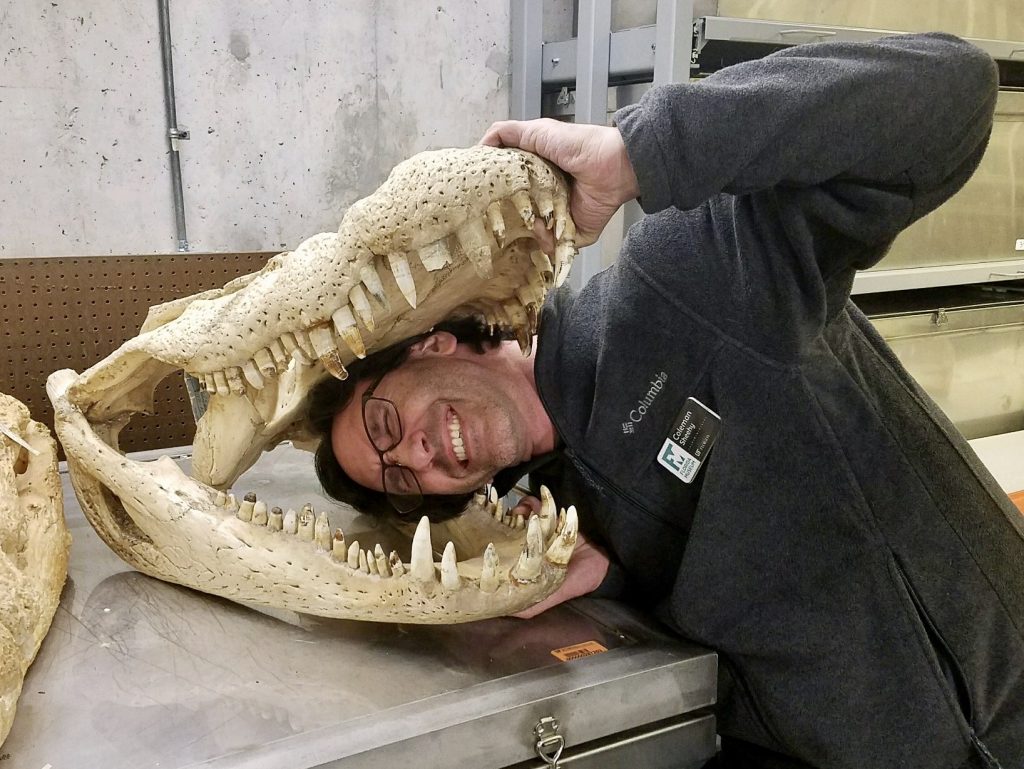 Coleman selfie with head in jaws of alligator specimen