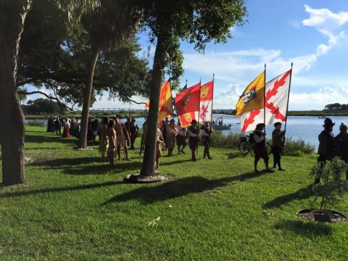 reenactors in Spanish clothing carrying flags