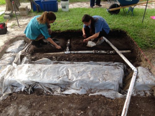 people digging around pvc pipes