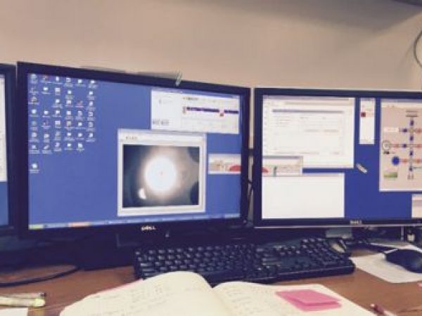 Figure 3: He degassing process. Visible laser beam degassing a packet in a single well (left computer screen). Illustrated pathway of He4, He 3, and varying pumps (right computer screen). Photo courtesy of Gephen Sadove.