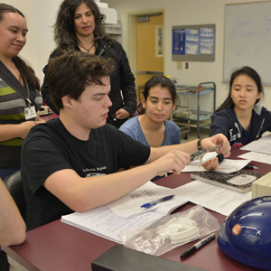 Dawn Mitchell (left, in back) and a teacher from West Shore High School observe students measuring 3D prints of horse teeth with calipers. Photo courtesy of UF CPET.