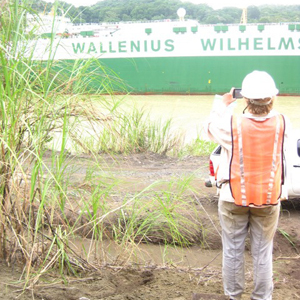 Paris Morgan takes a photo of a passing ship while doing fieldwork in the Panama Canal. Photo courtesy of Gina Roberti.