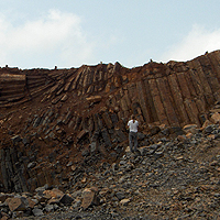 Man walking in front of rock face