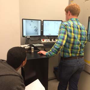 Museum intern Justy Alicea (left) and SMIF technician Jimmy Thostenson set up the CT scanner using a live X-ray image of teeth inside the scanner. (Photo courtesy of Andrea De Renzis)