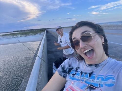 Man and Woman smiling while fishing on peir