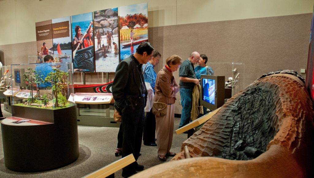 museum visitors enjoy the dug out canoe model.