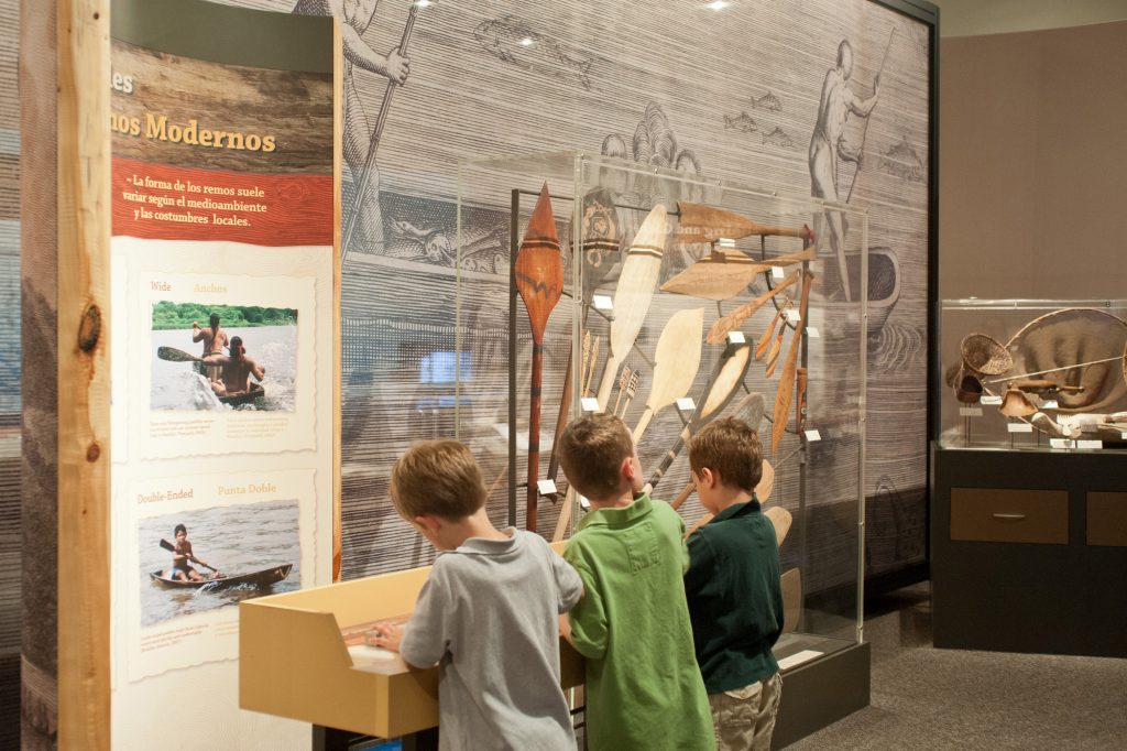 three young children looking at exhibit