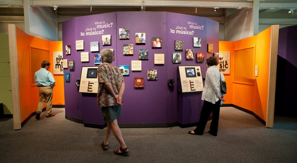 museum visitors look at photos and interactive displays