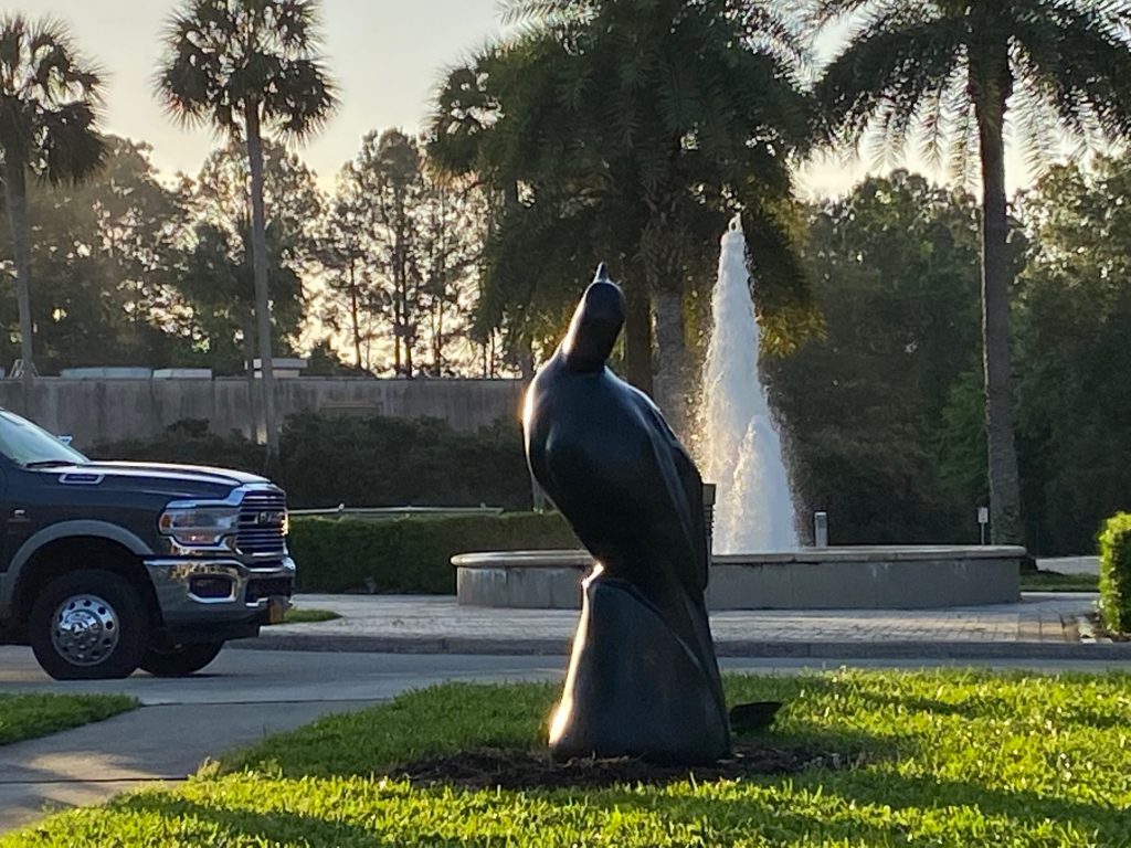 bird sratue contrast against a large water fountain