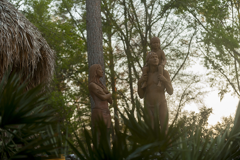 Diorama of three Calusa people - a woman and a man with a young child sitting on his shoulders.