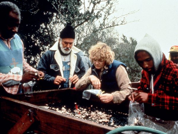 researchers looking over a sieve and sorting artifacts exposed