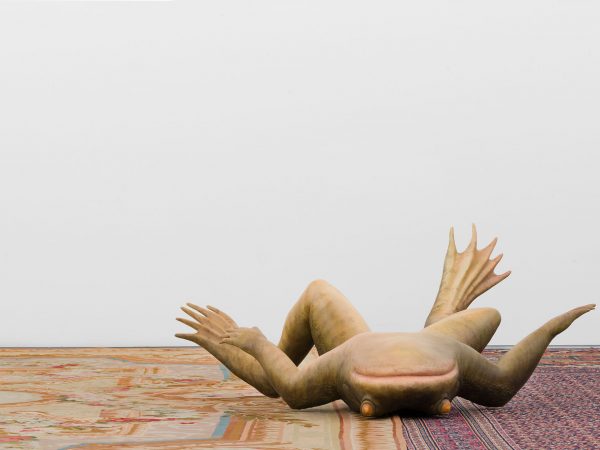 photo of fron statue, the frog is on its back with limbs spread