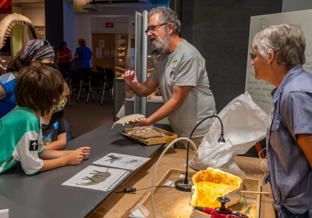 Scientists in the Fantastic Fossil exhibit lab speak with visitors about the specimen in the exhibit
