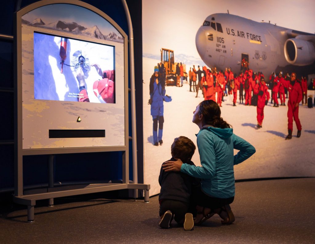 adult and child looking at a screen in exhibit