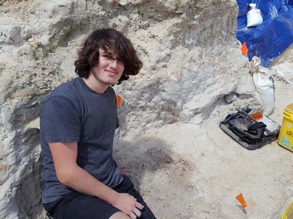 Ryan Dye with otter jaw discovery. Florida Museum photo by Dawn Dye.