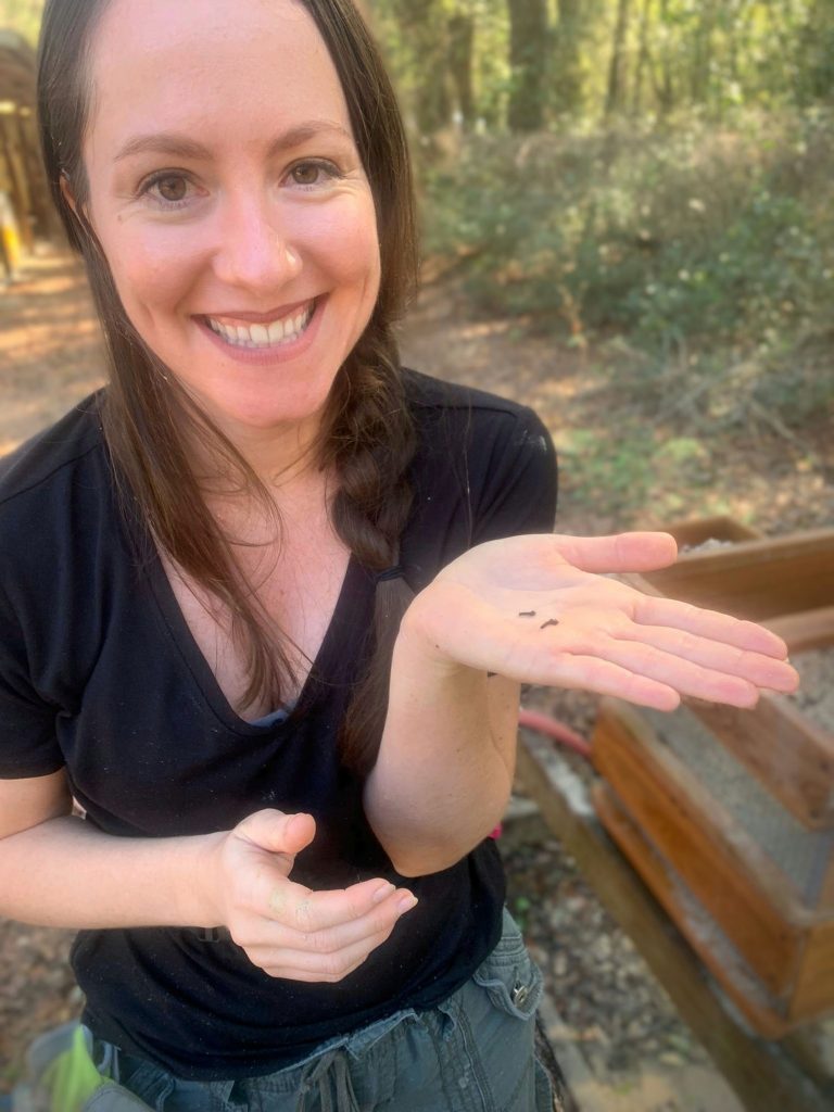 volunteer holding a small fossil in the center of her hand