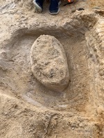 A hole dug around a fossil in preparation for jacketing