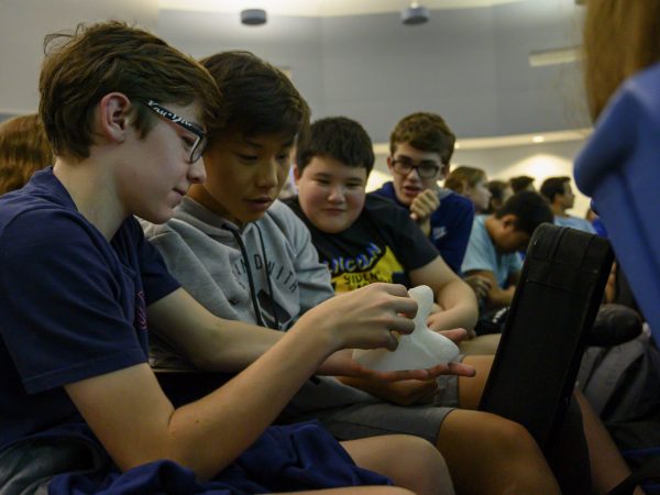Students examine 3D print of megalodon shark fossil tooth