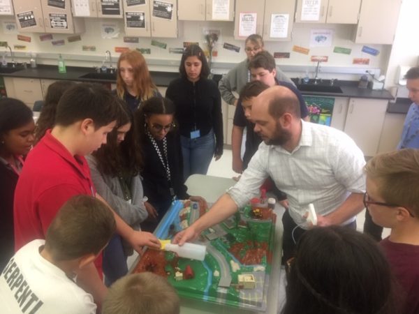 scientist and students manipulate the watershed water table model