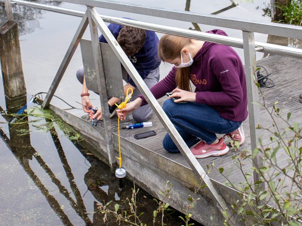 students test water near a river