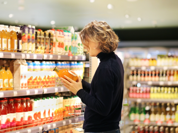 person shopping in a grocery store and looking at the label on a product