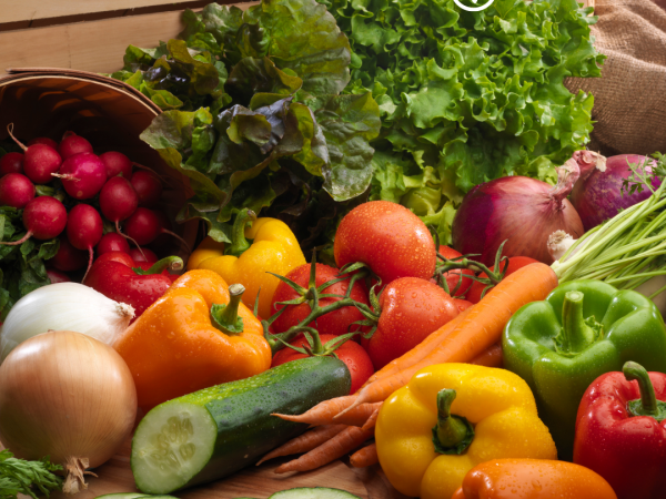 an array of fresh produce scattered across a wooden cutting board