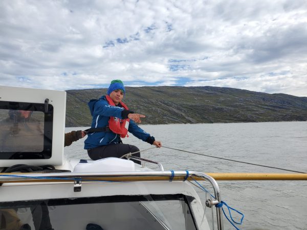 fernanda gastelu sits on a sailboat in a greenland fjord