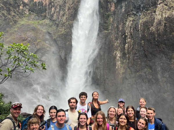 group of uf students and faculty pose in front of a waterfall on study abroad to North Queensland