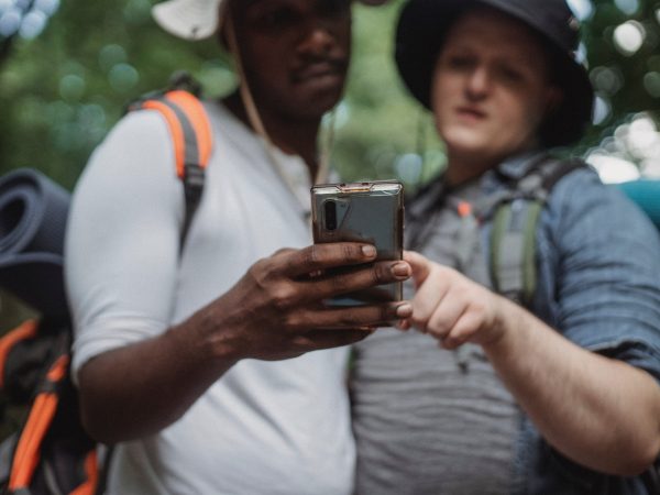 two travelers sharing smartphone during hiking trip