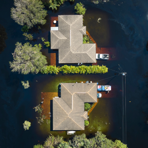 an aerial view of a house surrounded by water