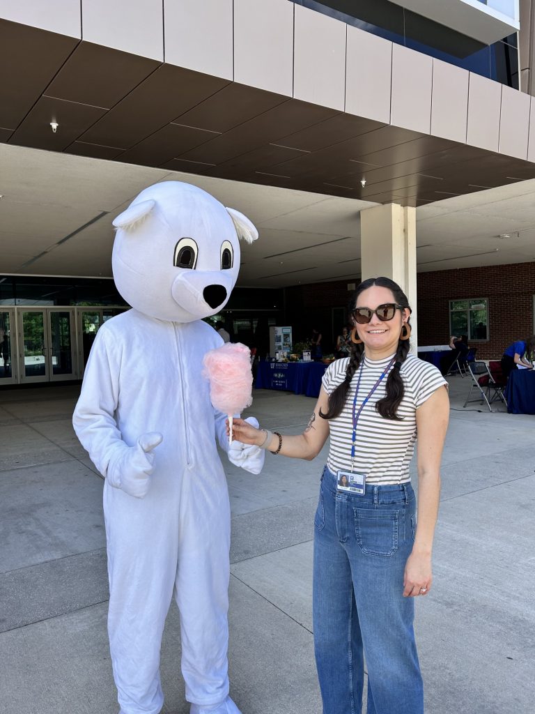 Sustainable UF's polar bear mascot holds pink cotton candy with the Sustainability cooridnator