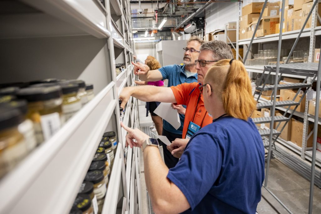 Keith Kusmirek and Brianna Allison peruse the fish collections' shelves together with collection manager Rob Robins.