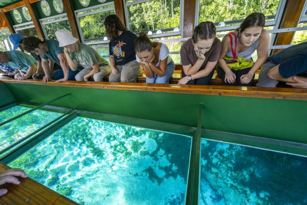 Fellows on the SIlver Springs glass bottom boat looking through the glass at the bottom of the springs.