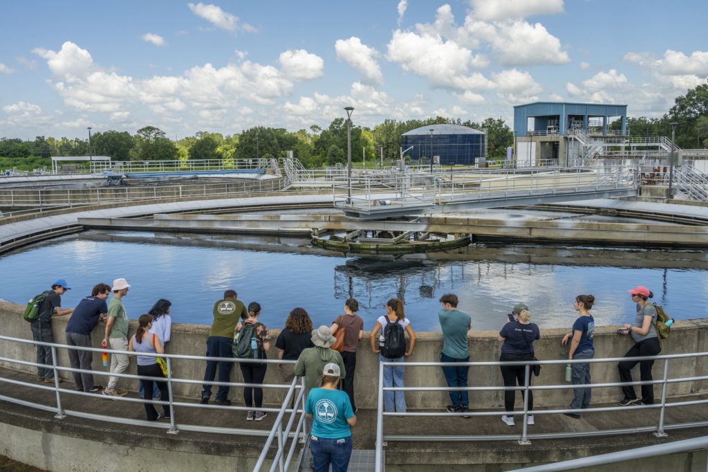 Fellows standing around large water storage area at the Ocala wastewater treatment plant.