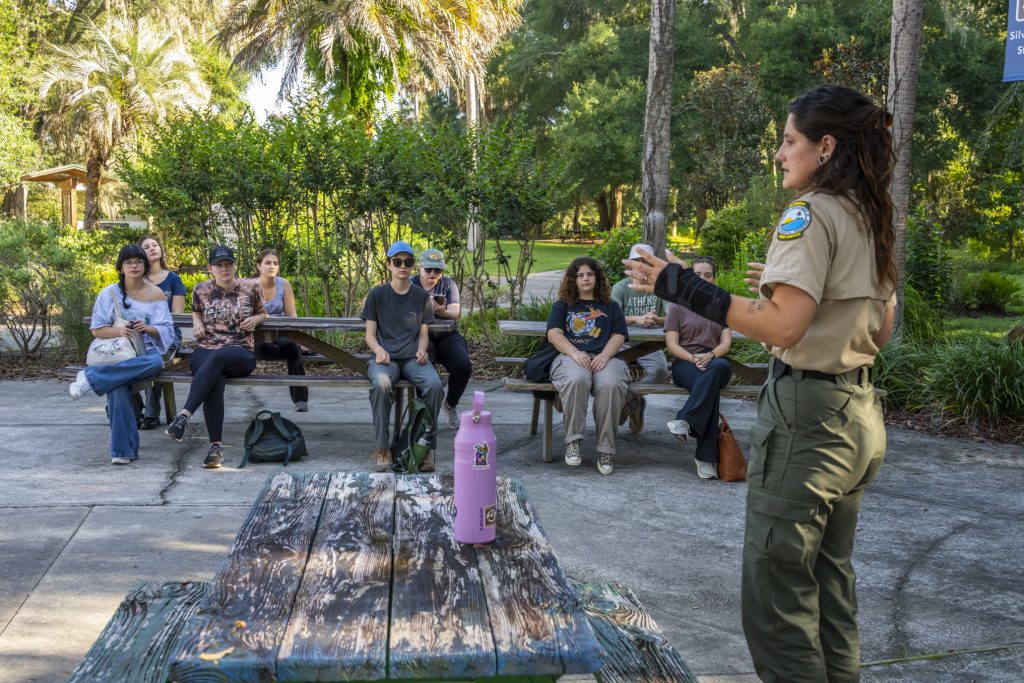 Park Ranger Courtney Freeman talks to fellows at Silver Springs picnic tables about federal careers.