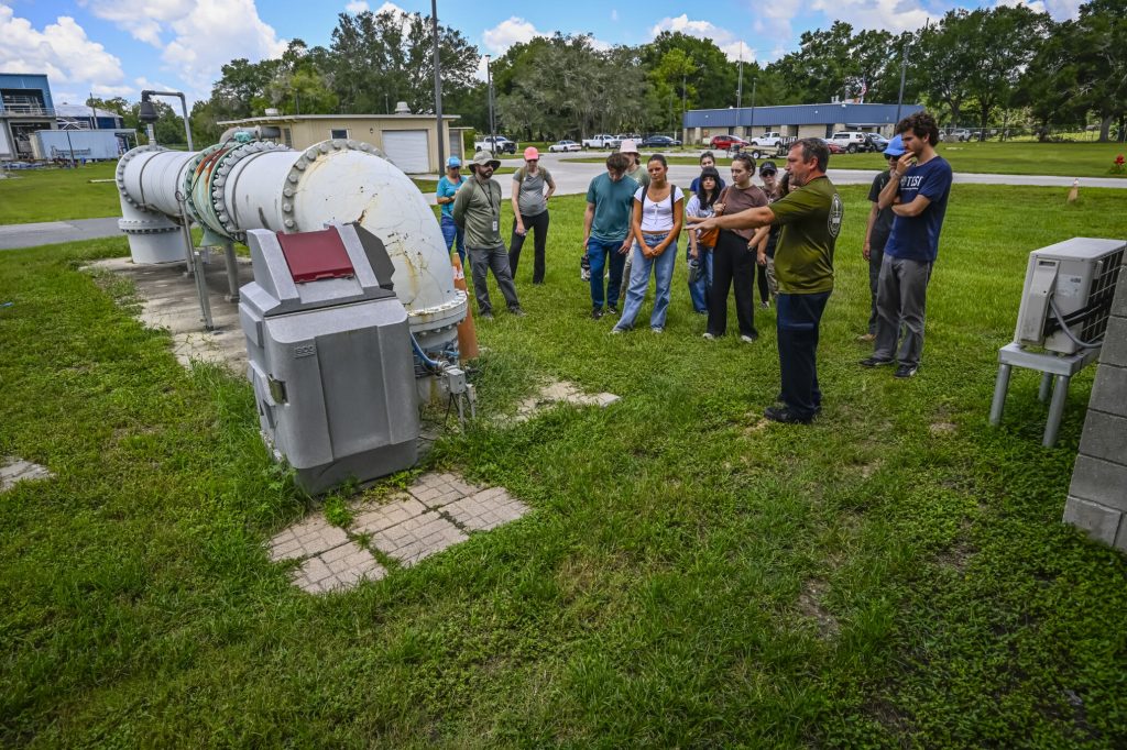 Fellows looking at machinery at the Ocala wastewater treatment plant.