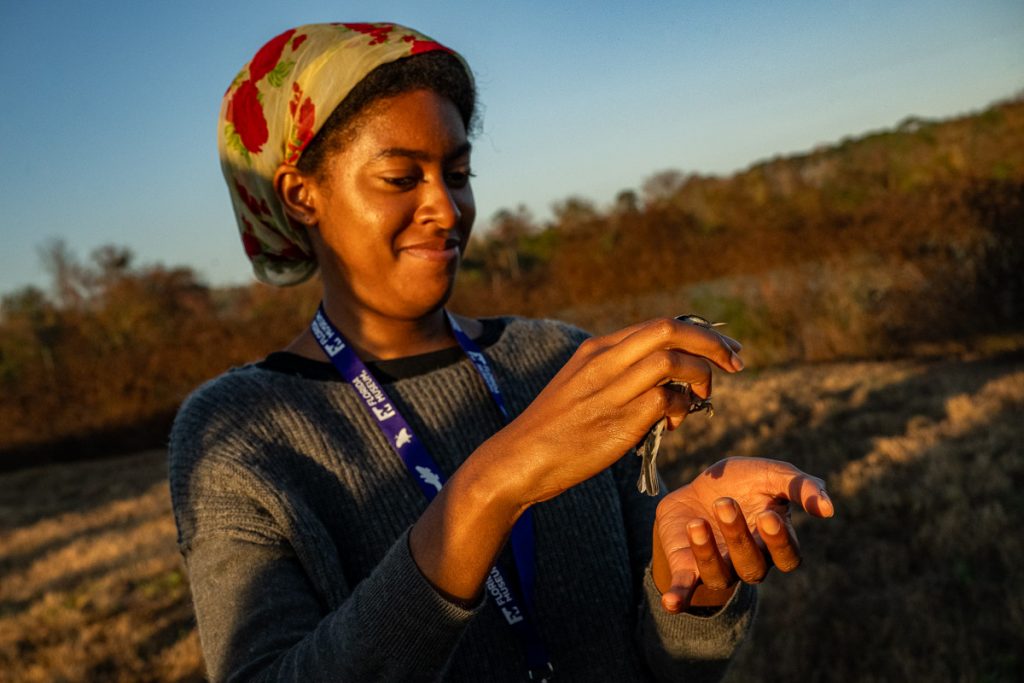 Azhalia hesitantly holds a banded bird